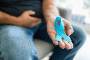 hombre sosteniendo lazo de conciencia contra el cáncer de prostata